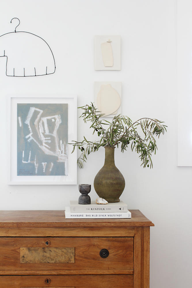 clay-vase-on-wooden-side-table-wall-art